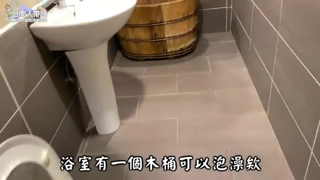 阿波在奮起湖大飯店房內展示浴室的木桶，準備體驗傳統泡湯