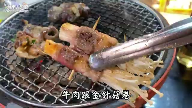 燒烤網上正在烤製牛肉金針菇卷，肉卷用竹籤串起，微焦上色