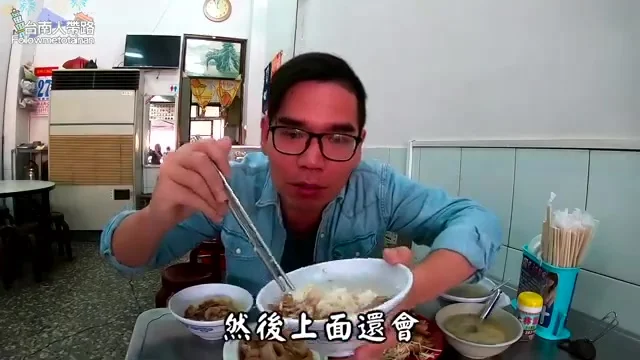 阿波夾起雞肉飯，準備品嚐20元銅板美味