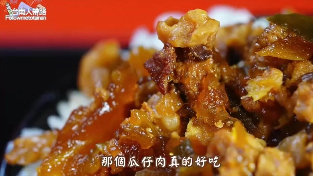 特寫拍攝深褐色滷肉丁鋪在白飯上，油亮誘人