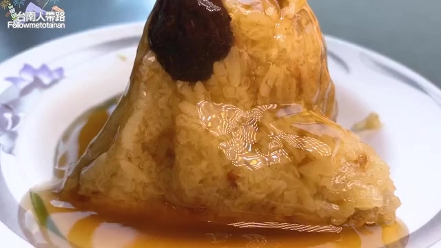透亮的肉圓淋上醬色油亮的醬汁，外皮呈現半透明糯米質地，上方點綴一顆深褐色配料