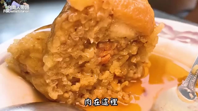 剖開的肉圓斷面，可見顆粒分明的糯米質地與深色肉餡混合其中，標示「肉在這裡」