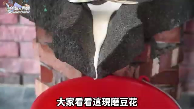 現磨豆花從石磨緩緩流入紅色容器,是南寮在地傳統豆花店的招牌製作過程