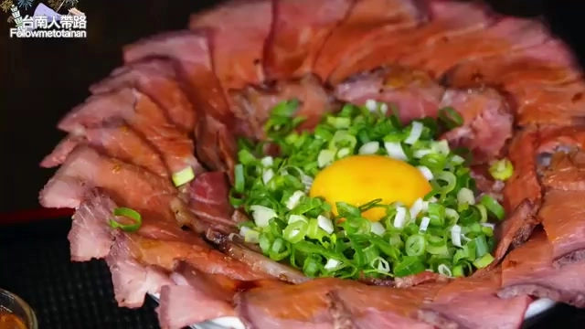 玫瑰花瓣造型排列的生牛肉片圍繞著中間的蛋黃與蔥花,色澤鮮豔擺盤精緻