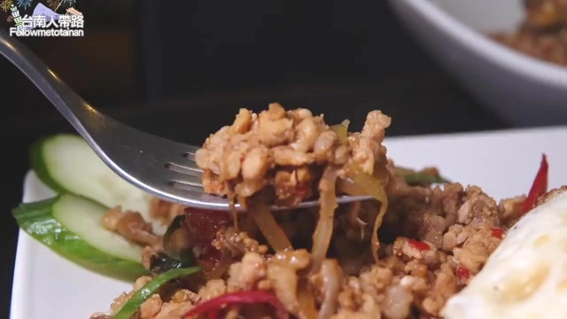 筷子夾起炒肉末,搭配小番茄、辣椒與小黃瓜片,色澤深褐油亮