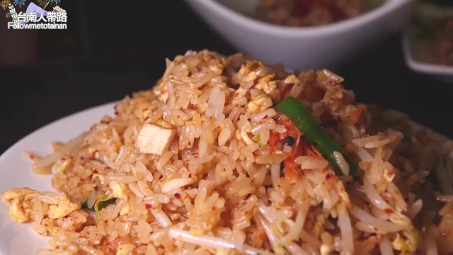 盤中盛著炒飯,摻雜蛋花與蔬菜丁,色澤金黃