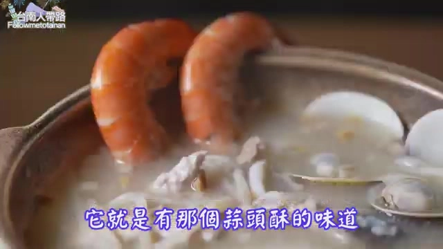 陶鍋裡的海鮮粥中盛著蝦子、蛤蜊與肉塊,湯頭濃稠帶著蒜頭酥香氣