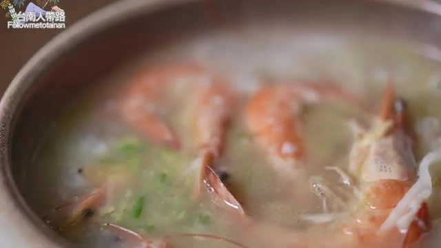 特寫粥碗中的蝦仁與白粥交融,湯色清澈帶著蝦紅色澤