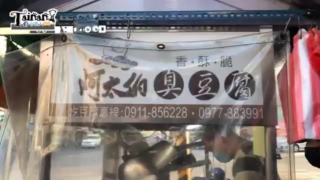 透明棚布下的臭豆腐攤位，招牌寫著「阿太伯臭豆腐」與訂購專線電話號碼