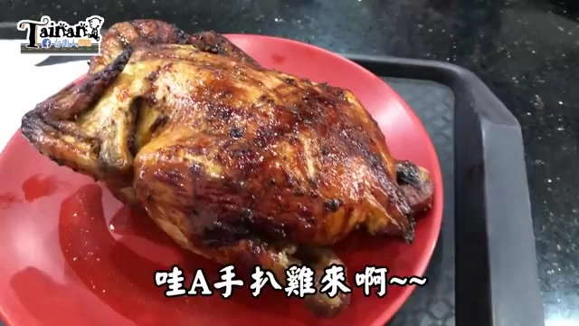 紅色圓盤上盛著整隻烤雞，外皮呈現焦糖色澤油亮誘人
