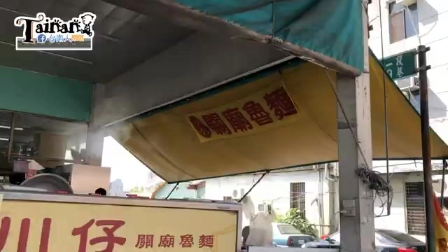 店家帆布招牌懸掛在遮陽棚下,寫著「川仔關廟魯麵」,另一側可見「關廟魯麵」的紅字招牌