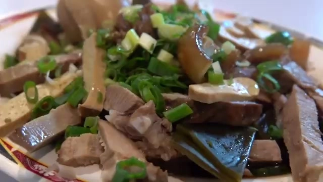 滷味拼盤裡豆干、肉片切片整齊，撒上蔥花色澤誘人