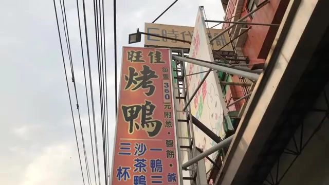 紅底招牌上寫著「旺佳烤鴨」，標示每隻360元附蔥、醬餅、鹹酥鴨、三杯等品項