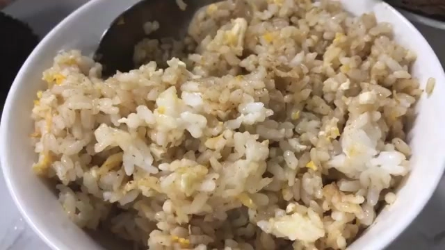 白色碗中盛著炒得油亮的鴨油炒飯，可見蛋花均勻拌入米飯