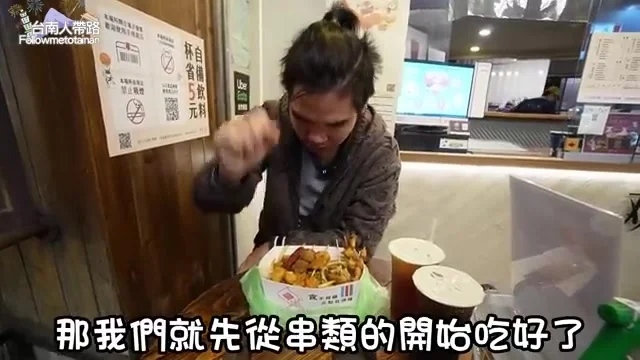 阿波伸手夾起串類,準備開吃花枝餃