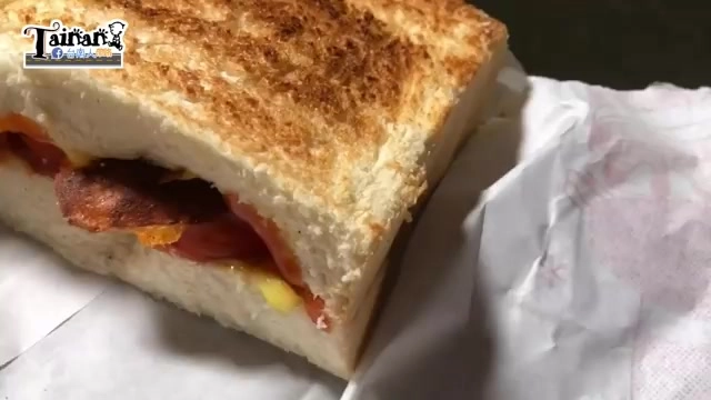 烤得金黃的土司剖面,夾著培根與滑嫩蛋液,餅皮微焦香