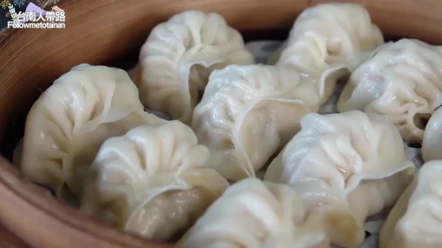 竹製蒸籠中整齊排列著多顆蒸餃,皮薄摺紋清晰