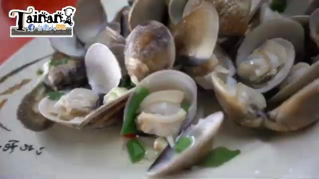 白色瓷盤盛著新鮮蛤蜊,佐以蔥花與辣椒點綴,殼身泛著油亮光澤