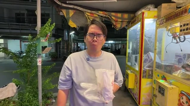 阿波站在攤位旁,手拿一大包鹽酥雞準備開吃