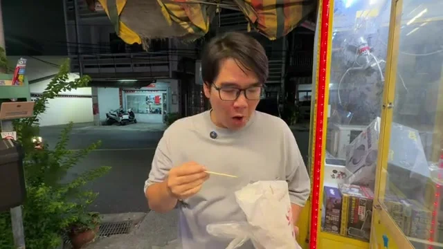 阿波用竹籤夾起食物準備入口,一旁是鹽酥雞紙袋