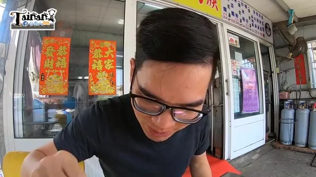 阿波坐在店門口低頭品嚐招牌香菇肉羹