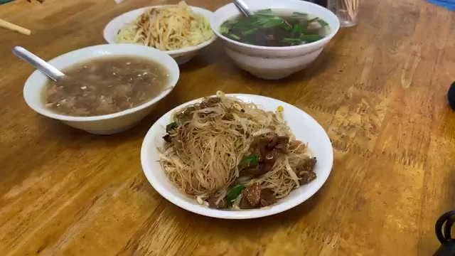 木桌上擺著四碗小吃：豬血湯、炒米粉、清湯與拌炒米粉，湯匙插在碗中