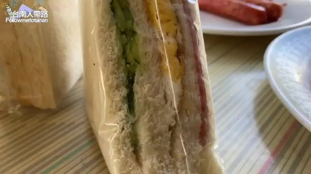 夾著蔬菜與蛋黃的三明治以透明袋包裝，切面可見層層食材