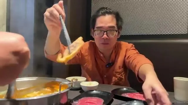阿波用長筷從鍋中夾起雞腿肉塊,準備給鏡頭看