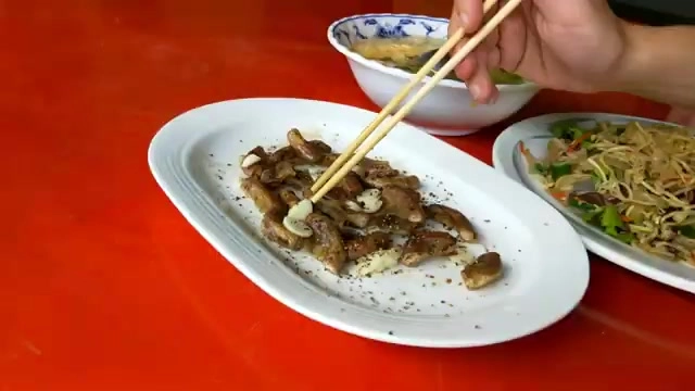 老闆自創的烤粉腸撒上黑胡椒，一旁還有現炒鍋氣十足的炒麵