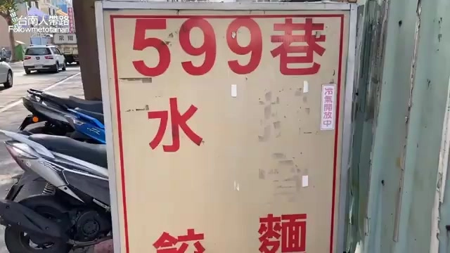 手寫招牌上寫著「599巷水餃 麵」，貼在店門旁牆面