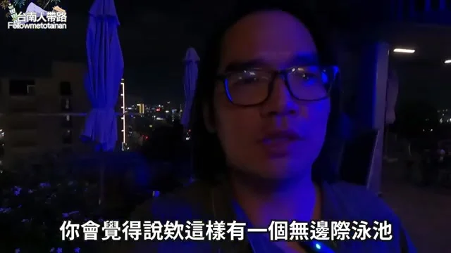阿波在酒店高樓層陽台向鏡頭介紹無邊際泳池