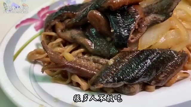 盤中盛著深色鱔魚片與炒麵，搭配洋蔥絲，標示「很多人不敢吃」