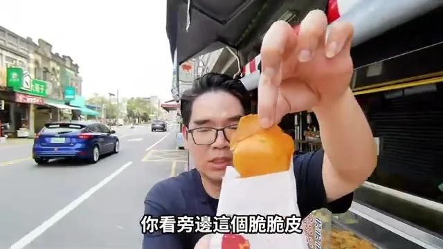 阿波拿著剛出爐的雞蛋糕,指著酥脆外皮特寫