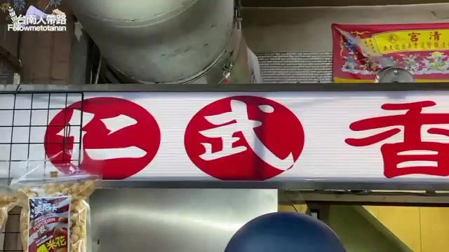 紅底白字招牌寫著「仁武香」字樣，燈箱懸掛在店門口上方