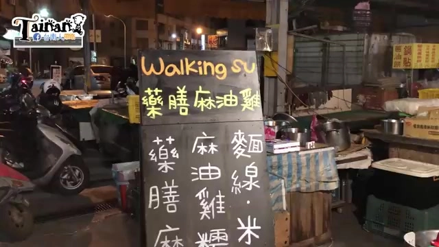 夜晚拍攝的手寫黑板招牌，寫著「Walking su 藥膳麻油雞」與「麻油雞糙、麵線、米血」等品項，攤位旁停放機車