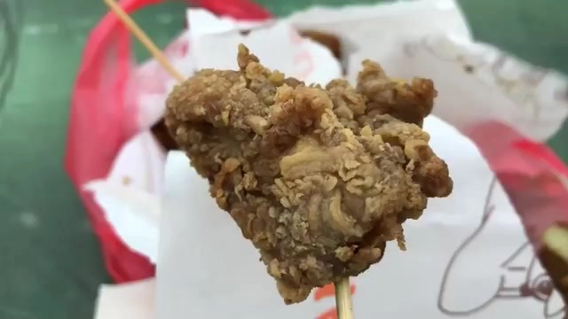 竹籤串起一塊酥炸雞肉,外皮呈現顆粒狀酥脆質地