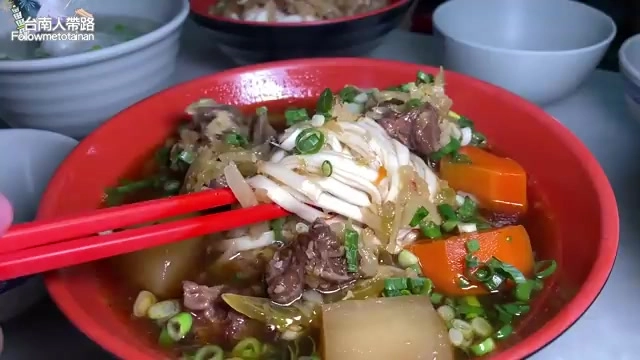 牛肉湯裡牛腱肉塊軟嫩帶筋，搭配紅蘿蔔與蔥花，湯頭濃郁色澤誘人