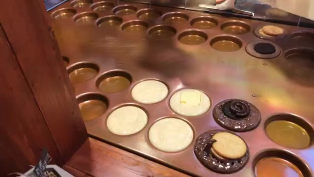銅製烤盤上正在烘烤各種口味的宇田燒,餅皮金黃柔軟