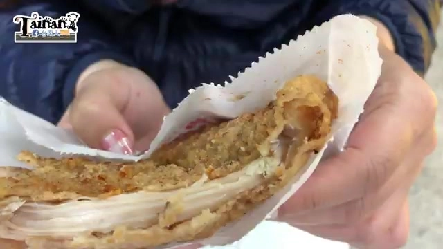 剛咬開的酒釀雞排斷面，外皮金黃酥脆，內部雞肉紋理清晰多汁