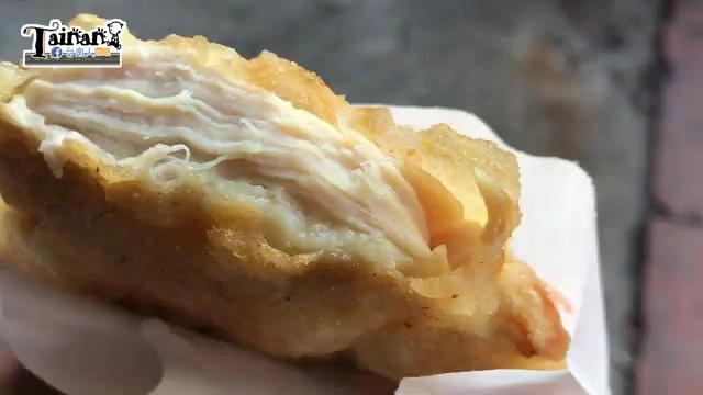 咬開的雞排斷面呈現豐富肉汁與紮實雞肉纖維，外皮金黃酥脆