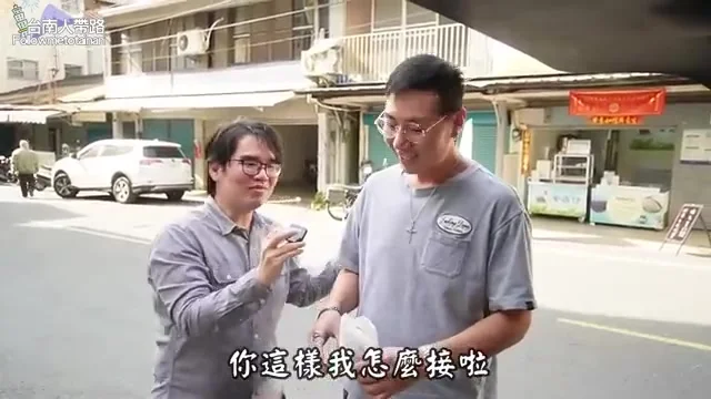 阿波與同行友人站在街邊,遞交30元雞腿排請友人試吃