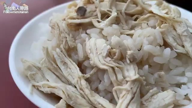 白飯上鋪滿撕成絲的雞肉，油亮誘人，份量鋪滿整碗