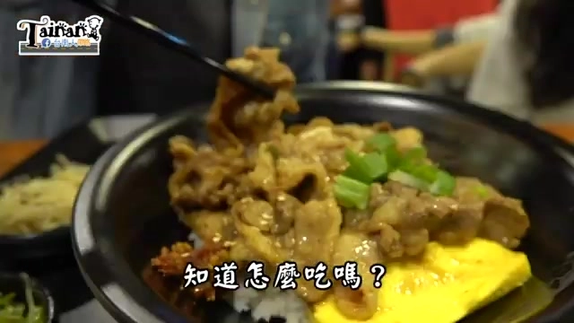 黑碗盛裝的燒肉飯,肉片沾附醬汁色澤油亮,鋪在鋪有煎蛋的白飯上,撒上蔥花