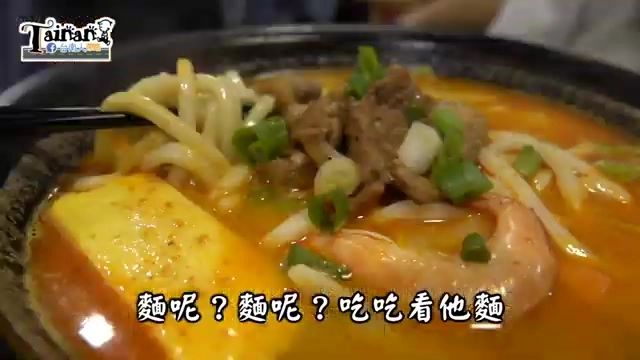 石鍋中盛著熱沙烏龍麵,湯頭橙紅濃郁,搭配牛肉、蝦子、豆腐與蔥花