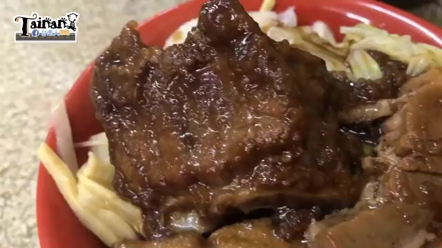 紅碗裡盛著滷排骨與豬腳，肉質色澤油亮，鋪在高麗菜與筍乾上