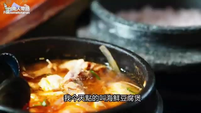 黑色石鍋中盛著海鮮豆腐煲，湯色紅潤，可見魚肉與豆腐塊，標示「我今天點的叫海鮮豆腐煲」