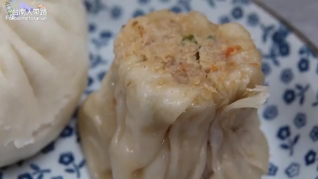 剖開的燒賣露出裡面豐富的內餡，帶著蔬菜丁與肉末，皮薄透亮