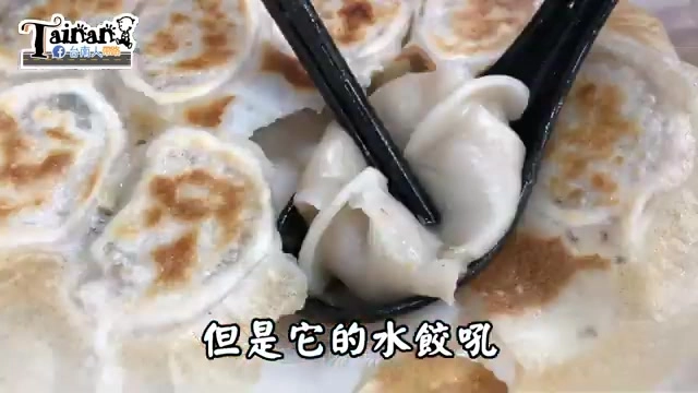 黑色湯匙夾起一顆餃子，內餡飽滿，周圍散落著煎餃的金黃焦香底部，字幕寫著「但是它的水餃吼」
