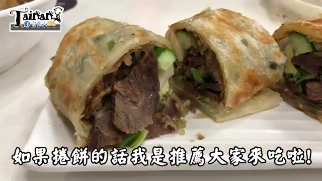 捲餅剖半特寫，餅皮呈現金黃焦香色澤，內餡可見大塊牛肉與翠綠小黃瓜、蔥花，字幕寫著「如果捲餅的話我是推薦大家來吃啦!」