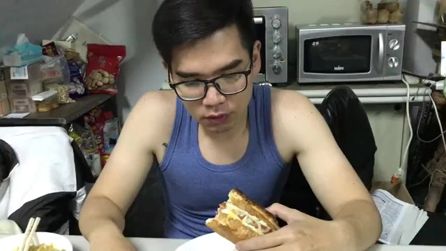 長型法國麵包夾著食材，酥脆表皮可見明顯烤痕，被雙手捧著品嚐